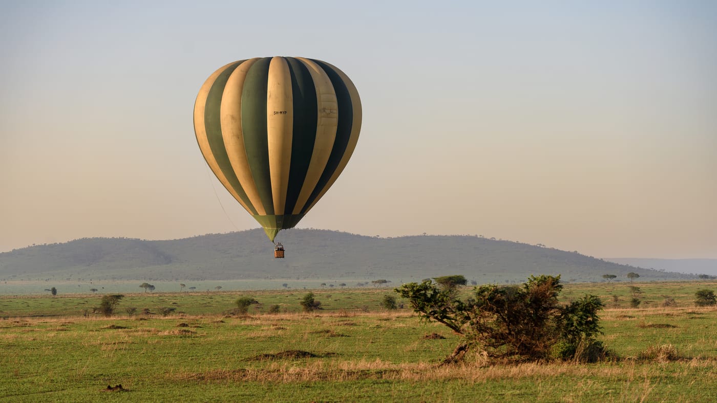 A hot air balloon drifting over the African savannah at sunrise